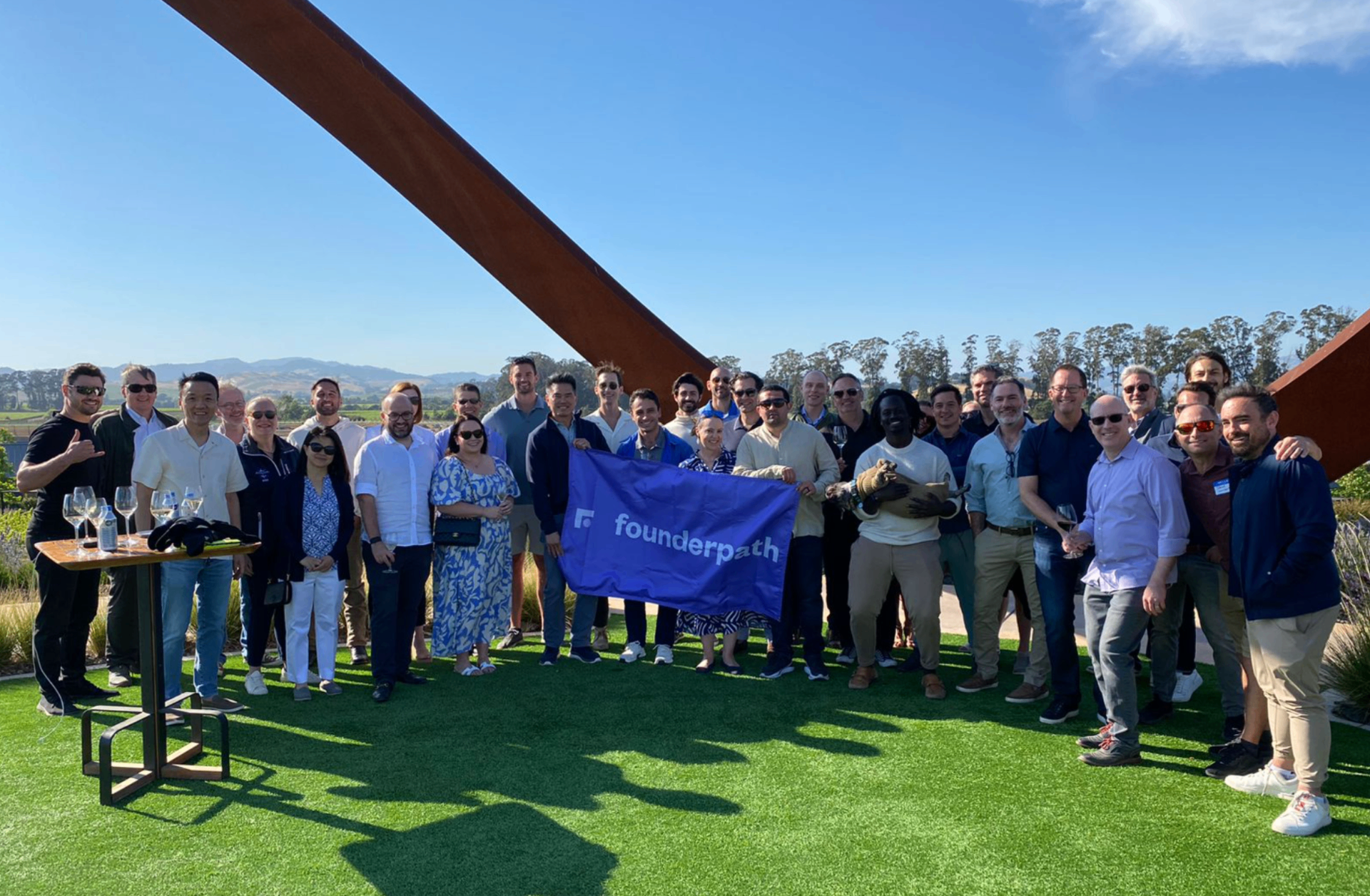 Group of executives and founders at outdoor mastermind event with Founderpath banner