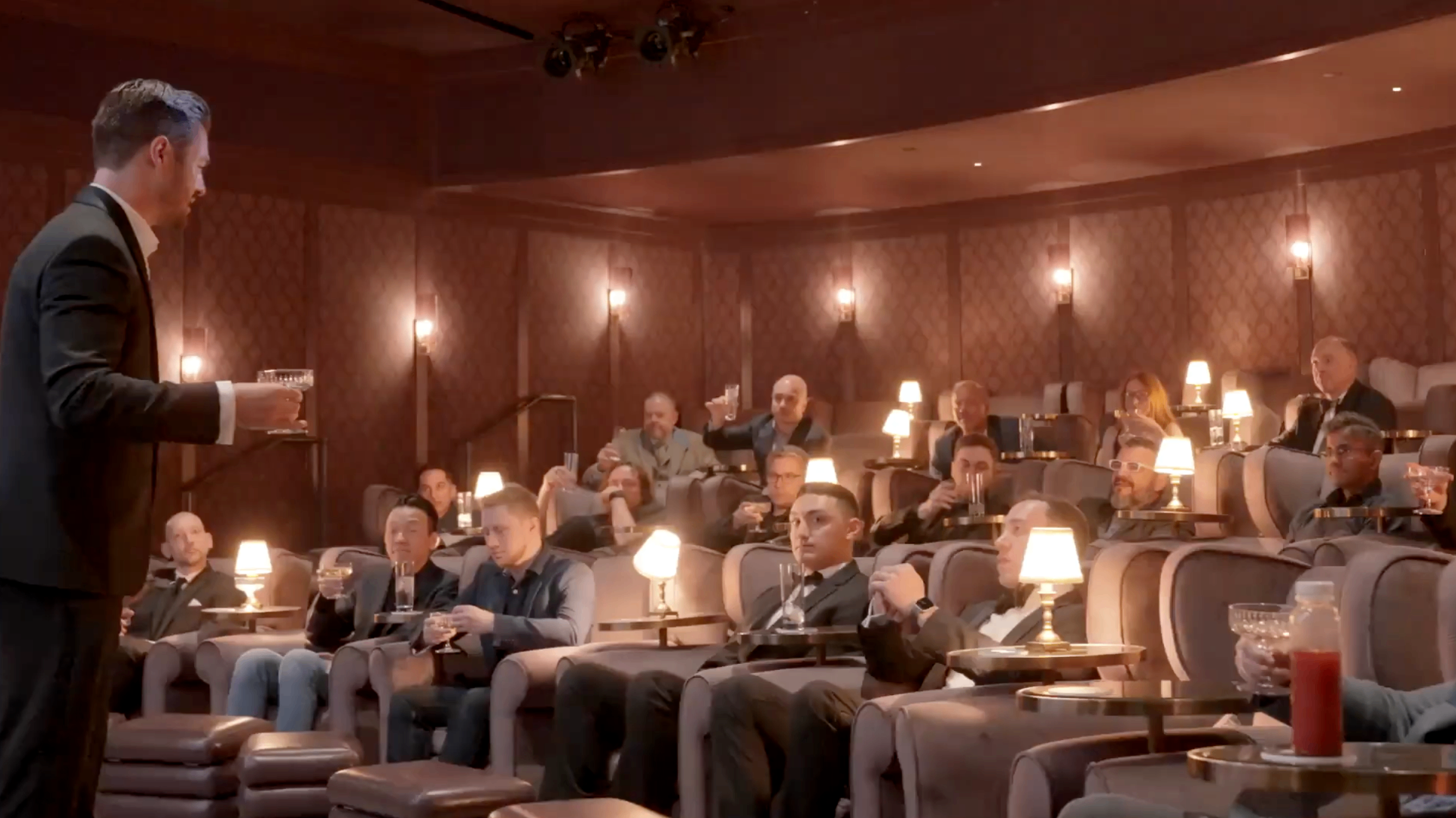 Entrepreneurs relaxing in luxury cinema-style seating at exclusive mastermind event